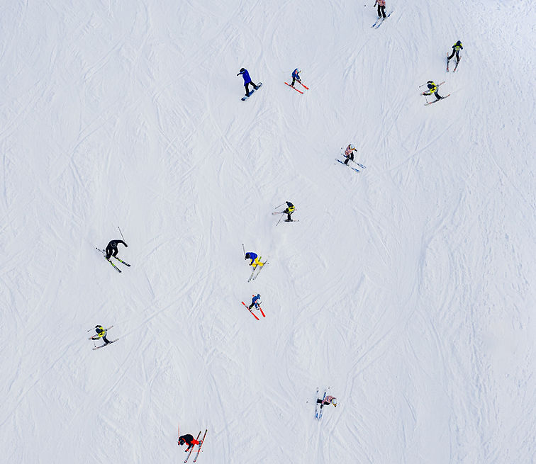 Skiers op piste van bovenaf gefotografeerd