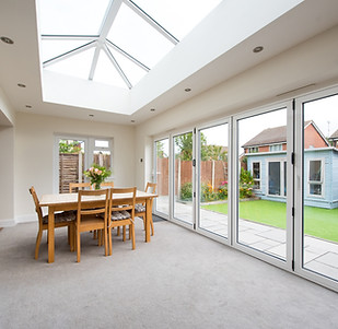 A general interior view of a home extension used as a dining room with dining table and ch