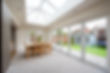 A general interior view of a home extension used as a dining room with dining table and chairs