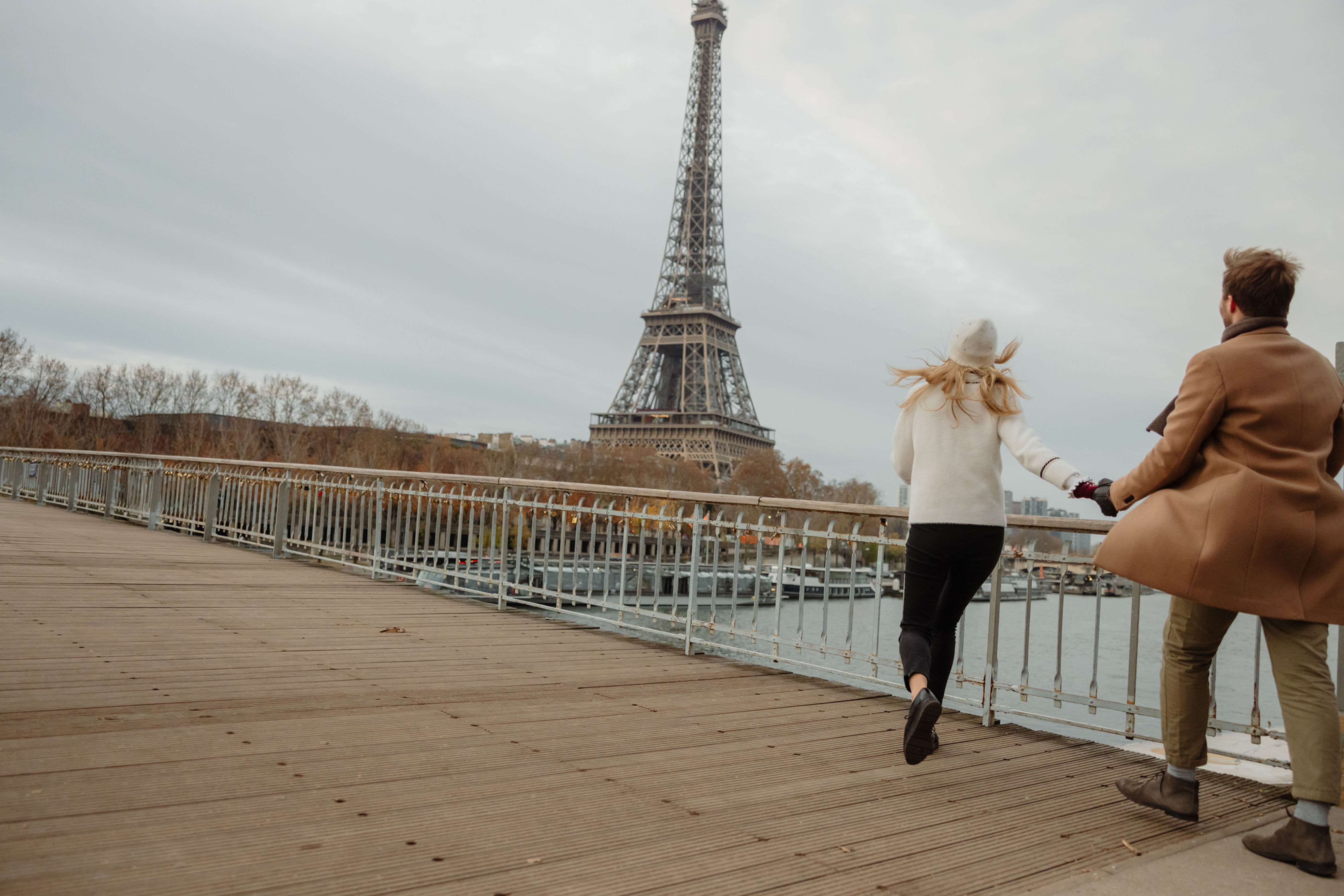 A couple walking near the Eiffel Tower in Paris, representing signature multi-city luxury travel experiences.