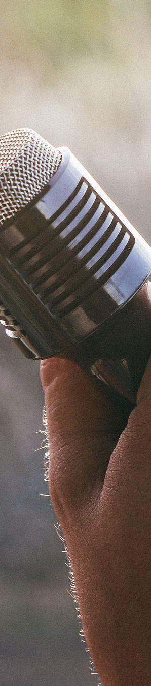 Hand holding a vintage style microphone outdoors