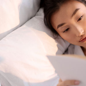 A lady reading a book on how to begin her investing journey