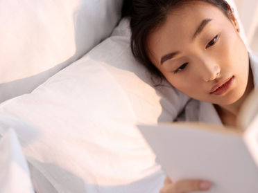 A lady reading a book on how to begin her investing journey