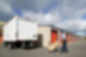 A delivery man outside a warehouse with boxes