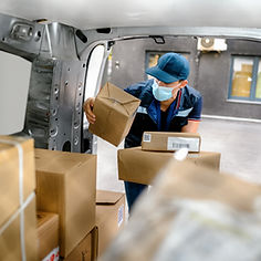 Delivery man holding cardboard box and unloading parcel for delivery