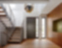 A modern foyer with a sleek staircase featuring wooden steps and metal railings
