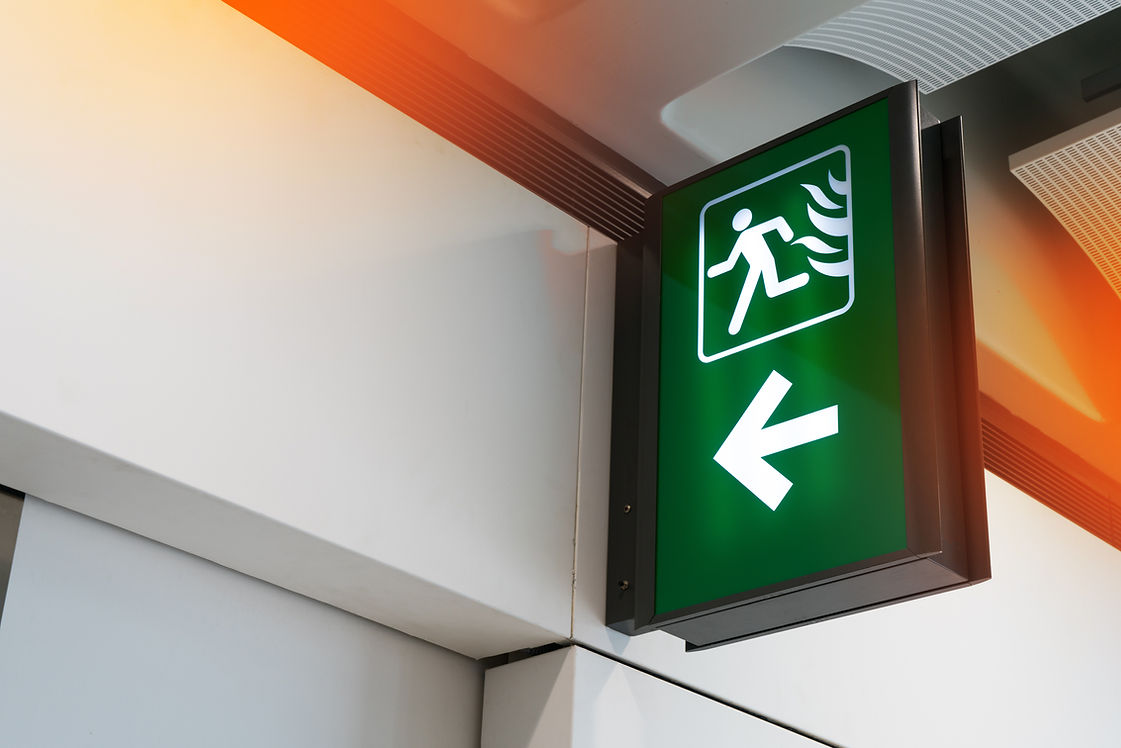Fire exit sign lightbox in the airport terminal emergency exit way. Green emergency exit s