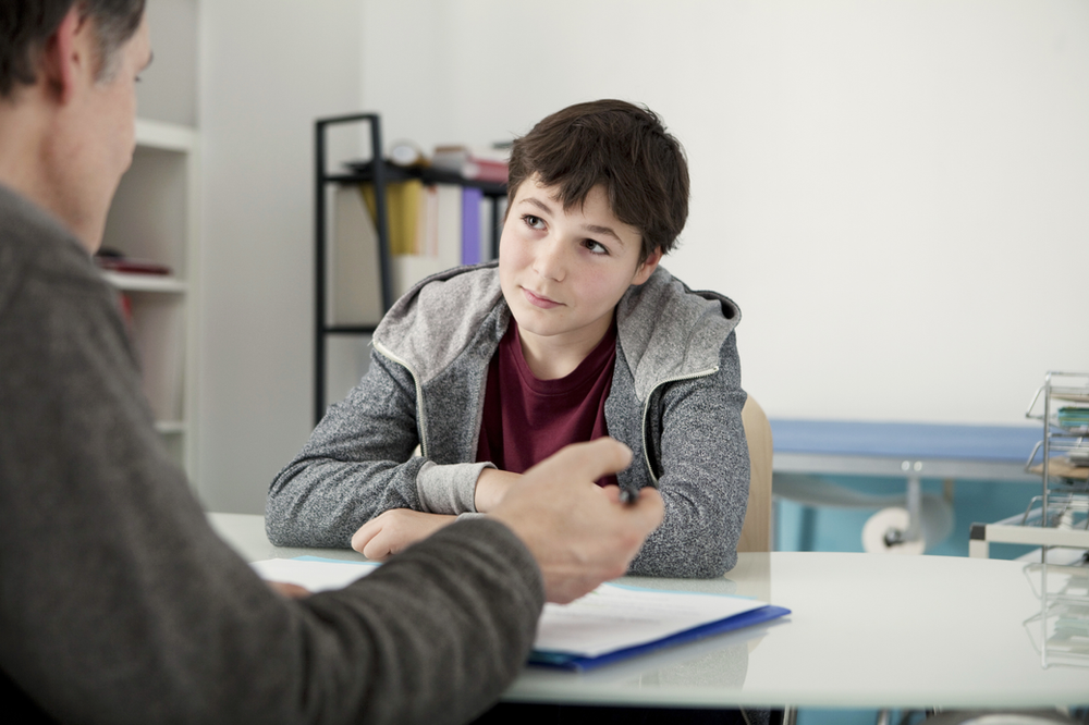 A young boy meets with a social worker