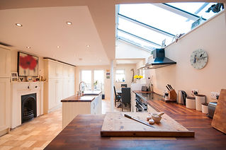 A modern kitchen featuring a spacious island and a bright skylight.