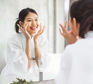 A woman applying facial moisturiser