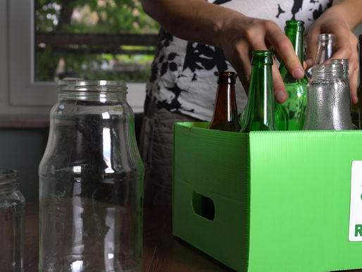 glass and other recyclables in a green recycling box