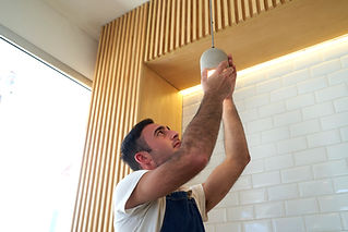A professional installing a ceiling light