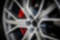 Close-up of modern alloy car wheel. The brake disc is visible behind the wheel bars