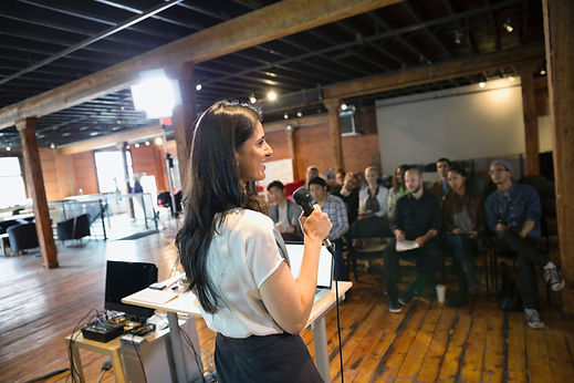 Woman speaking into a microphone during an office workshop seminar