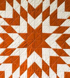Picture of a red and white star quilt.