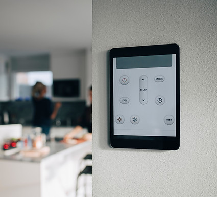 Thermostat app on digital tablet mounted over white wall at home