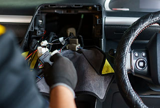 a mechanic fixing car dashboard's wiring