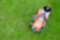 Gardener mowing lawn on ride on mower with mulching blades, shot from overhead