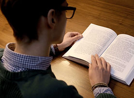 Man with glasses reading a book