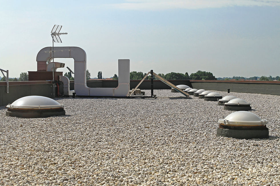 Flat gravel roof with skylight domes on a commercial building