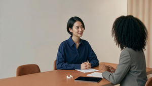 A woman sitting at table being interviewed for a job