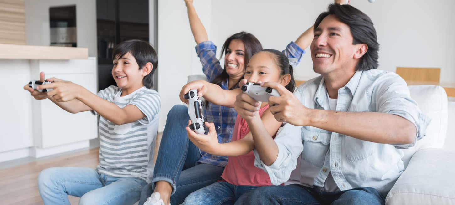 Happy family playing video games together at home