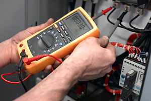 Close-up view of a person inspecting the voltage from the wire connections