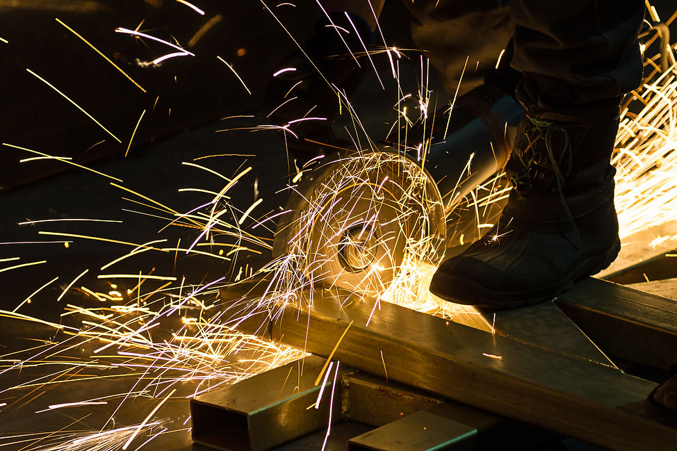 A professional welder precisely cutting steel pieces.