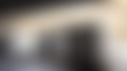 Three trucks parked at a loading dock under a roof during sunset. The sky is orange, creating a calm mood.