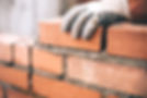 close-up image of a worker's hand while laying bricks