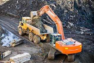 excavator loading dirt into a dump truck at construction site
