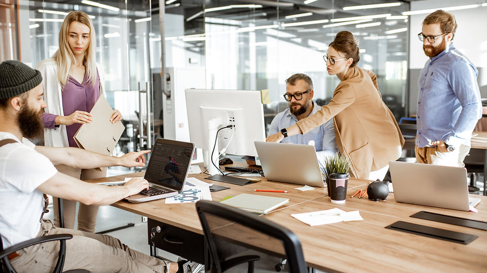 Mitarbeitende koordinieren Aufgaben und Genehmigungen in einem modernen Büro mithilfe digitaler Arbeitsprozesse.