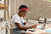 a women writing at a desk using creative prompts to get over creative block 