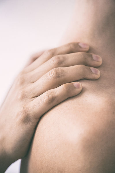 Patient Touching Painful Shoulder Caused by a Rotator Cuff Injury