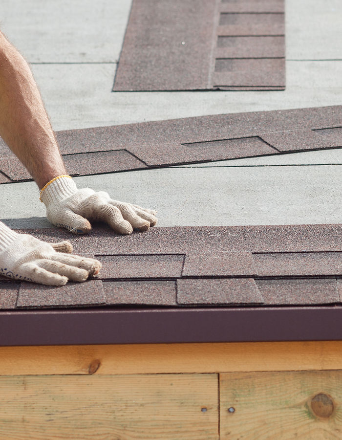 Roofer laying new asphalt shingles