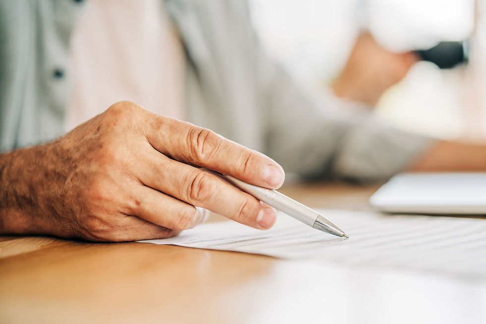 Close-up of person pointing pen at printed document on wooden desk during meeting