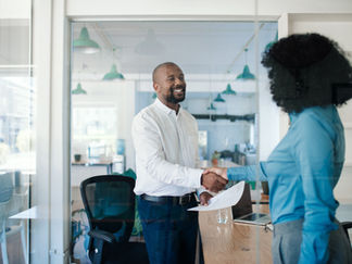 Two people shaking hands about to start a job interview