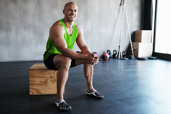 Mann ruht sich im Fitnessstudio aus