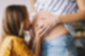 Daughter Kissing Pregnant Mom