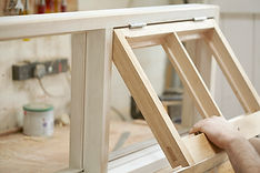 Carpenter in workshop workshop marking out wood to fit a hinge on a newly made cupboard
