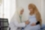 A pregnant patient being evaluated by a doctor