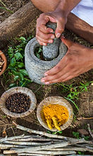 Herbs on a tray and in a mortar and pestle for use in ayurveda