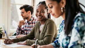 Individu souriant avec deux autres collègues
