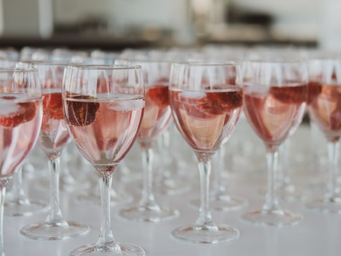 Copas de vino con líquido Color Rosa en fila sobre mesa celebración.