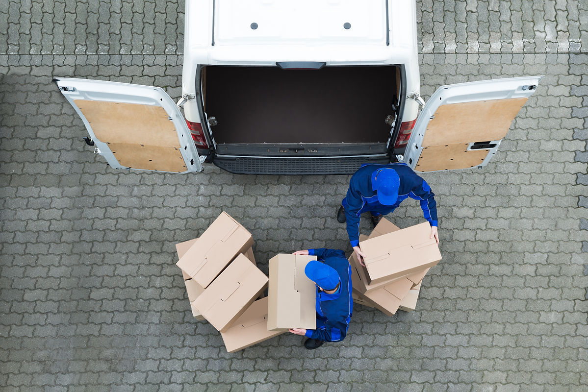 Two person taking parcels out of delivery van