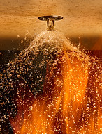 Fire Sprinkler mounted in a ceiling spraying water on a fire