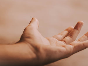  יד מושטת של אדם נוגעת בחפץ, מסמלת חיבור או גילוי.