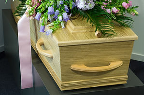 A coffin in a morgue with a flower arrangement