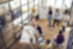Mitarbeiter diskutieren in modernem Büro als Symbol für Open Strategy bei Dynaxity Consulting
