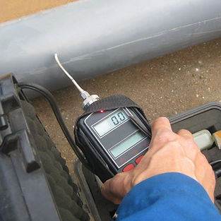 An engineer check for gas from the pipe with the help of a device